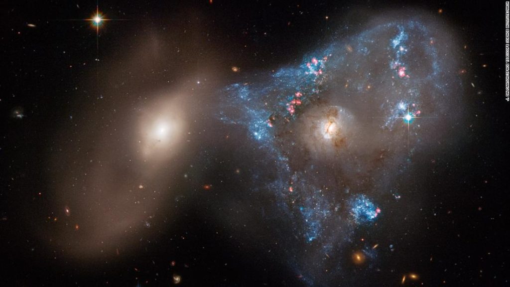 Two galaxies colliding together form an unusual space triangle