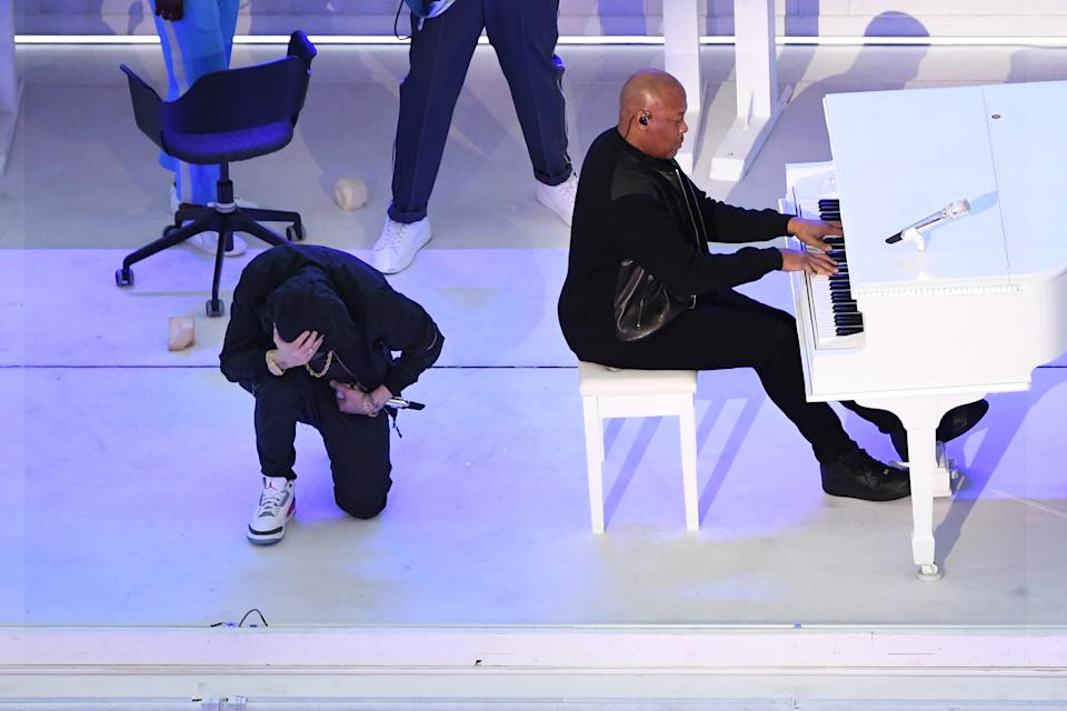 TOPSHOT - American rapper Eminem kneels on stage as he performs with American rapper Dr. Dre during the halftime show of the Super Bowl LVI match between the Los Angeles Rams and the Cincinnati Bengals at SoFi Stadium in Englewood, California, on February 13, 2022. (Photo) By VALERIE MACON/AFP) (Photo by VALERIE MACON/AFP via Getty Images)