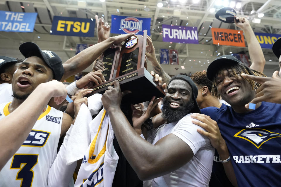Chattanooga goalkeeper David Jean Baptiste, second from right, holds the championship trophy with his teammates to celebrate their victory over Foreman in the NCAA college basketball championship game for the Southern Conference Championship, Monday, March 7, 2022, in Asheville, North Carolina (AP Photo/Kathy Kmunesque)