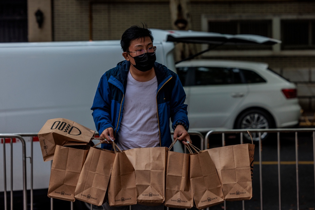A delivery worker brings food to an enclosed residential community in Shanghai, China, April 23, 2022.