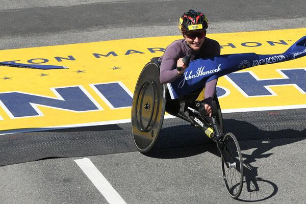 Switzerland's Manuela Schar crosses the finish line to win the women's wheelchair race at the 2022 Boston Marathon.