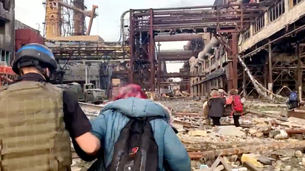 Members of the Azov Regiment walk with civilians during UN-led evacuations from the sprawling Azovstal steel plant, nearly two months after the city's siege war by Russia during its invasion, in Mariupol, Ukraine in this still photo from a post released on 1 May 2022. 
