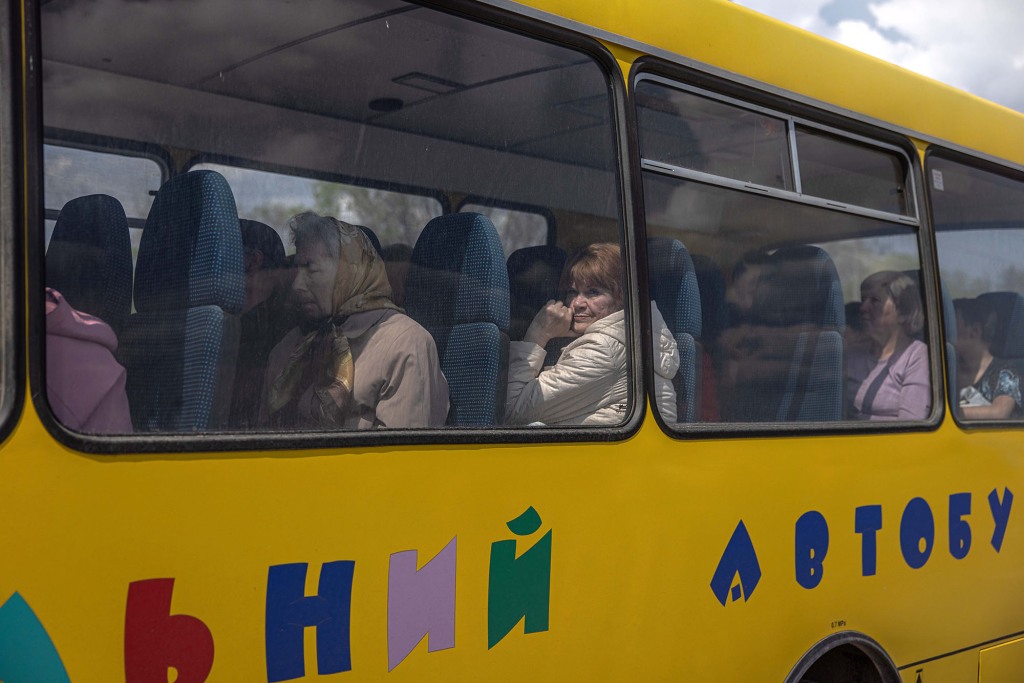 Internally displaced people sit on a bus after arriving from the frontline town of Urekiev, at the evacuation point in Zaporizhia, Ukraine, May 2, 2022