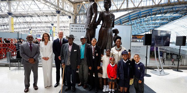 Prince William, Catherine, Duchess of Cambridge, Baroness Floella Benjamin, right, Windrush passengers Alford Gardner, center, John Richards, fourth from left, and children at the Windrush National Monument created by Jamaican artist Basil Watson, left, at Waterloo Station in London On June 22, 2022.