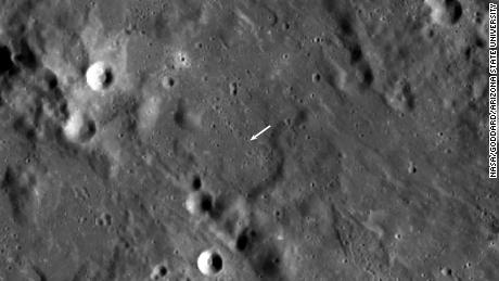 The new crater is smaller than the other crater and not visible in this view, but its location is indicated by the white arrow. 