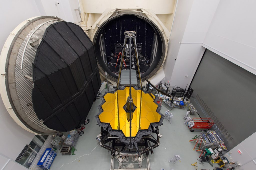 NASA's James Webb Space Telescope sits in front of the door to Chamber A, a giant thermal vacuum chamber located at NASA's Johnson Space Center.  The telescope will soon be moved into the room, where it will spend a hot summer in Houston undergoing tests in frigid temperatures.  The telescope will operate under the extremely low temperature of 50 K (-223 degrees Celsius or -370 degrees Fahrenheit) in space, so NASA is simulating those conditions on Earth, ensuring that optics and instruments perform optimally after launch.