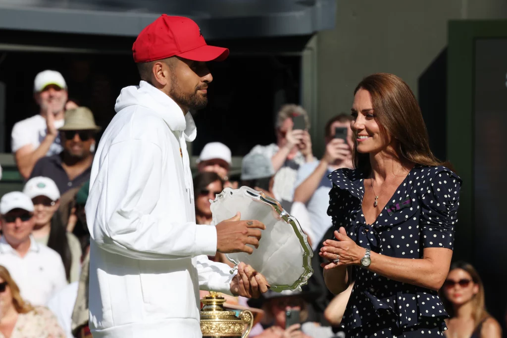 Nick Kyrgios wearing a red hat at Wimbledon, defying the all-white dress code