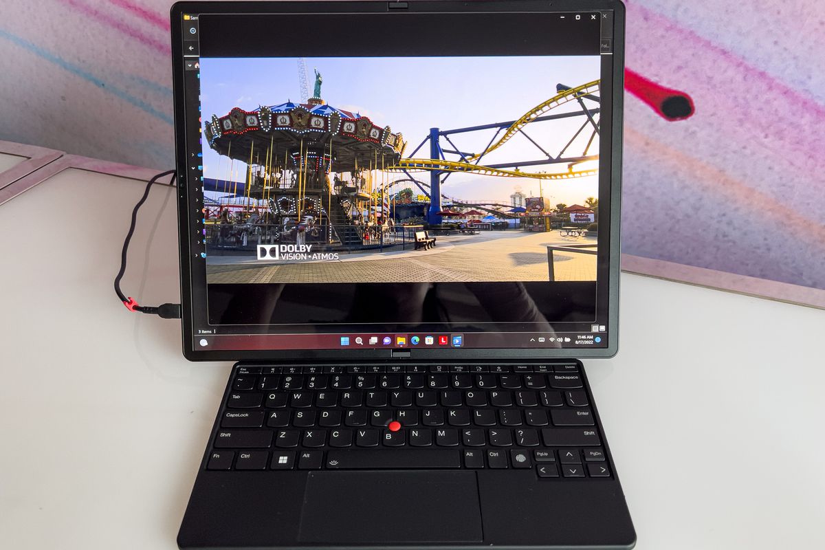 ThinkPad X1 Fold in tablet mode with Bluetooth keyboard in the display area.  The screen displays a vortex image.