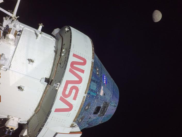 NASA spacecraft in space with the moon in the distance