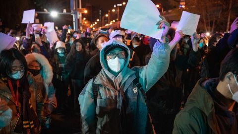Demonstrators hold white papers during a protest in Beijing on November 28.