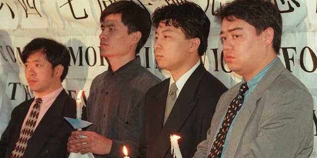 Chinese student leaders held a candlelight vigil outside the Chinese Embassy in Washington on June 3 to commemorate the seventh anniversary of the Tiananmen massacre.  Students who led the protests in Tiananmen later fled China. Pictured from left to right: Liu Gang, Zhou Fengsu, Chen Tong, and Weer Kaishi. 