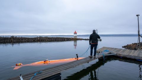 An autonomous underwater vehicle called Hugin (left) surveys a Norwegian lake.